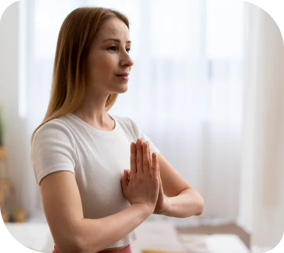 A woman meditating calmly at home